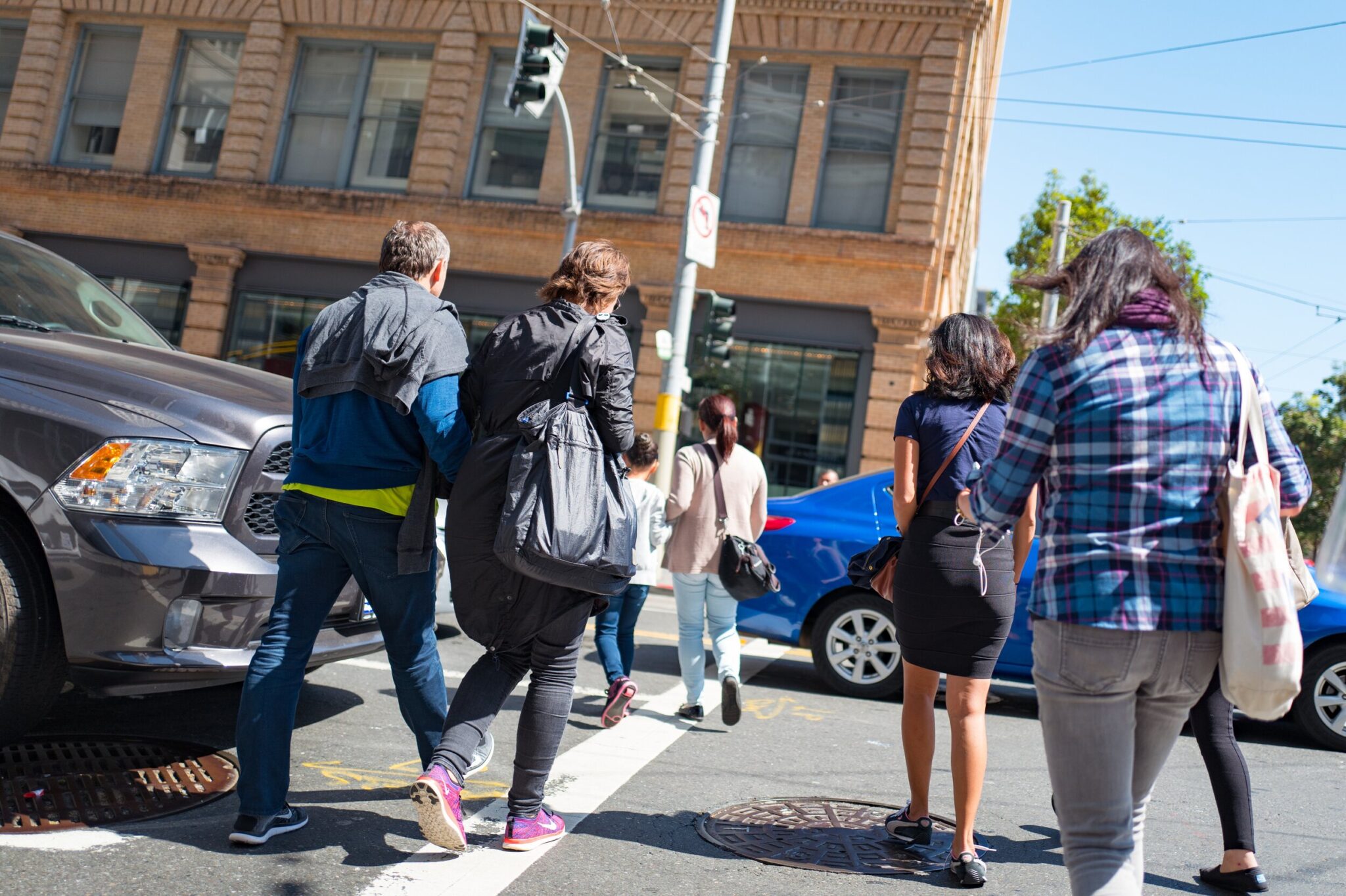 Pedestrians in a crosswalk on a sunny city street